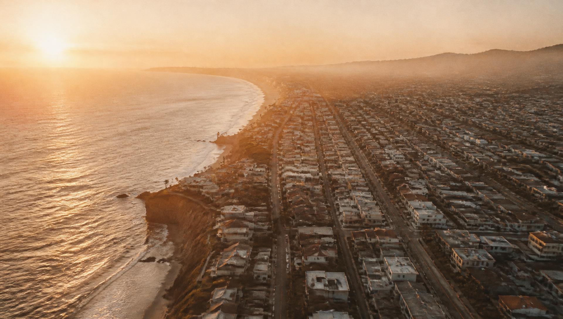 Aerial view of a South Bay coastal city grid meeting the Pacific at golden hour